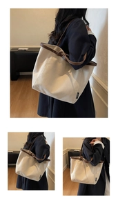 Detail of canvas tote bag with dark brown leather trim and shoulder straps on white canvas