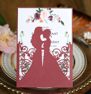 Detail of burgundy laser-cut wedding invitation featuring a romantic couple silhouette
