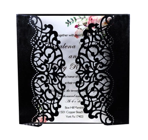 Close-up of laser-cut wedding invitation with intricate floral hollow design and insert