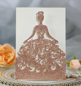 Detail of rose gold glitter laser-cut princess dress invitation on elegant ceramic plate