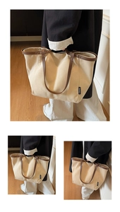 Detailed view of beige canvas tote bag with brown leather trim and shoulder straps