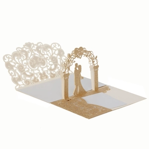 Macro detail of laser-cut 3D wedding card showing glittery gold hollow floral patterns