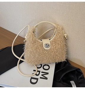 Detailed view of cream faux fur handbag with silver metal lock on a leather jacket