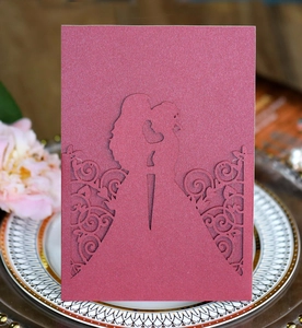 Laser-cut pink glitter wedding invitation featuring a romantic couple silhouette