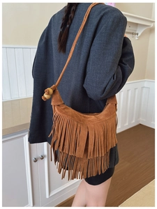 Detailed back view of a brown suede tassel shoulder bag with wooden beads and long fringes