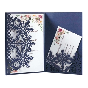 Detail of laser-cut navy blue snowflake invitation with elegant floral inner card