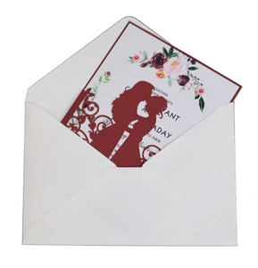 Detail of laser-cut burgundy invitation cover with couple silhouette and floral inner card