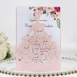 Detailed laser-cut bridal dress wedding invitation on a golden glass tray