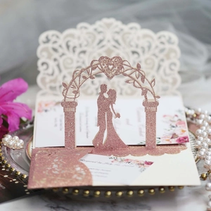 Detail of rose gold glitter laser cut wedding invitation with romantic silhouette