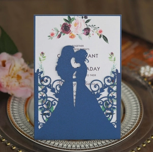 Navy blue laser-cut wedding invitation featuring a romantic silhouette on a luxury plate