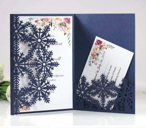 Detail of laser-cut navy blue snowflake invitation with floral inner card and RSVP set