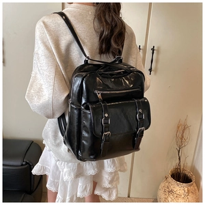 Rear view of a black glossy faux leather large capacity backpack worn on a model
