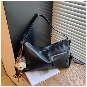 Detail of black underarm bag with leopard bow teddy charm and smooth leather texture