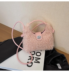 Detail of pink faux shearling handbag with metallic twist lock and smooth leather strap