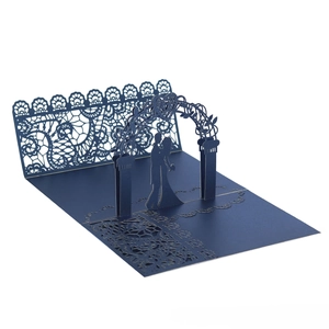 Detail of 3D laser-cut lace wedding invitation with silhouettes of newlyweds and archway