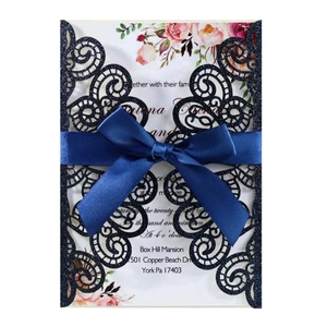 Dettaglio dell'invito di nozze blu navy glitterato tagliato al laser con fiocco di seta