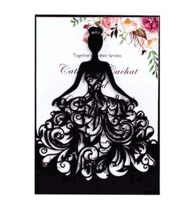 Close-up of laser-cut wedding invitation featuring a bride silhouette and intricate patterns