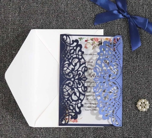 Detail of laser-cut wedding invitation with pink floral inner card and blue covers