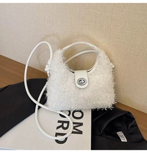 Detail shot of white faux fur handbag featuring a rotating metal clasp and leather strap