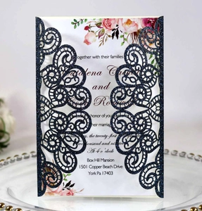 Détail d'invitation de mariage découpée au laser bleu marine avec motifs floraux