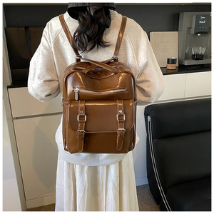 Brown vintage faux leather backpack with double buckle pockets and silver hardware detailing