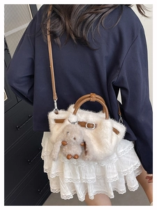 Vue arrière d'un sac seau en peluche blanche avec poignées en cuir marron et breloque lapin