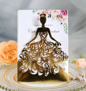 Close-up of laser-cut golden wedding invitation with intricate princess gown patterns