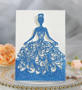 Macro detail of laser-cut glitter paper wedding invitation in blue princess dress shape