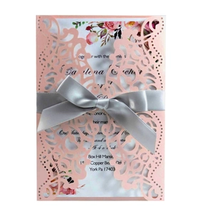 Laser-cut floral wedding invitation set with light pink cover and silver satin ribbon