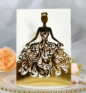 Close-up of laser-cut wedding invitation featuring a gold mirror silhouette on a ceramic plate