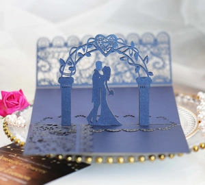 Detail of 3D laser cut wedding invitation with navy blue metallic heart and couple silhouette