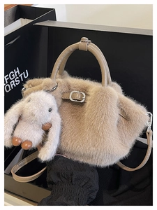 Nahaufnahme der khakifarbenen Plüschtasche mit Silberschnalle und süßem Hasenanhänger