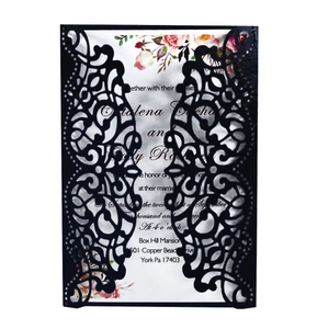 Detail showing laser-cut black hollow wedding invitation with floral patterns and white insert