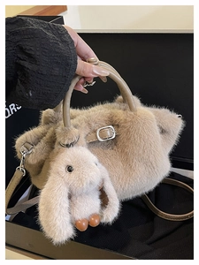 Detailansicht der beigen Kunstpelz-Handtasche mit Hasenanhänger und Ledergriffen