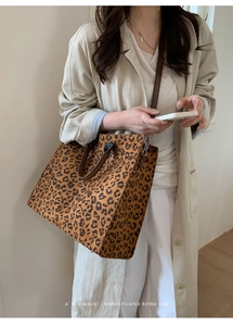 Dettaglio della borsa tote leopardata con manici in pelle marrone e tracolla regolabile