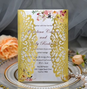 Detailed laser-cut gold wedding invitation with elegant floral print and pearl accents