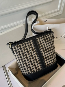 Classic black and white houndstooth bucket bag with black leather trim and gold hardware