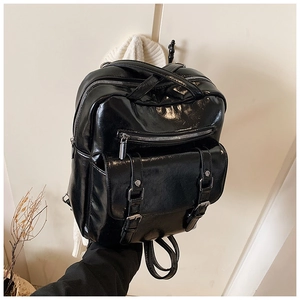 Detail of vintage black oil skin backpack with multi-layer zippers and double buckles