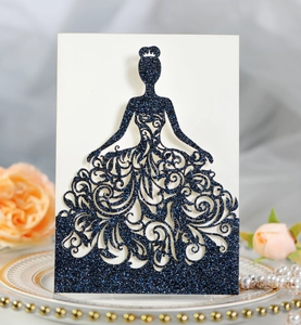 Macro detail of laser-cut wedding invitation featuring a glittery blue gown silhouette