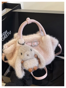 Details einer rosa Plüschhandtasche mit süßem Hasenanhänger und Lederriemen-Akzenten
