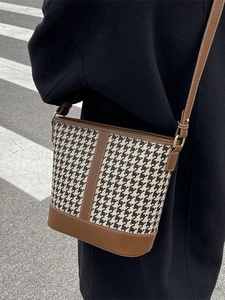 Classic houndstooth bucket bag with brown leather trim and adjustable crossbody strap