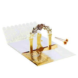 Detail of 3D laser-cut wedding invitation featuring a gold arch and romantic couple silhouette