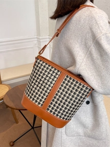 Vintage houndstooth bucket bag with brown leather trim and stylish shoulder strap