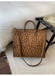 Dettaglio borsa shopper leopardata con manici in pelle marrone e chiusura magnetica