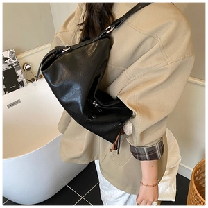 Black leather underarm bag with glossy pebble texture and silver zipper detail