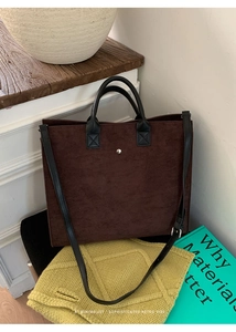 Dettaglio borsa tote minimalista in feltro marrone scuro con manici in pelle nera