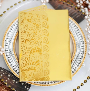 Macro detail of laser-cut lace pattern on golden metallic wedding invitation