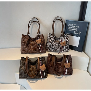 Dettaglio di quattro borse tote leopardate in varie tonalità con ciondoli a orsetto