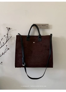 Dettaglio borsa tote in pelle scamosciata marrone scuro con finitura opaca e borchia