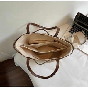 Detailed interior of minimalist canvas tote bag showing zipper pockets and large compartments